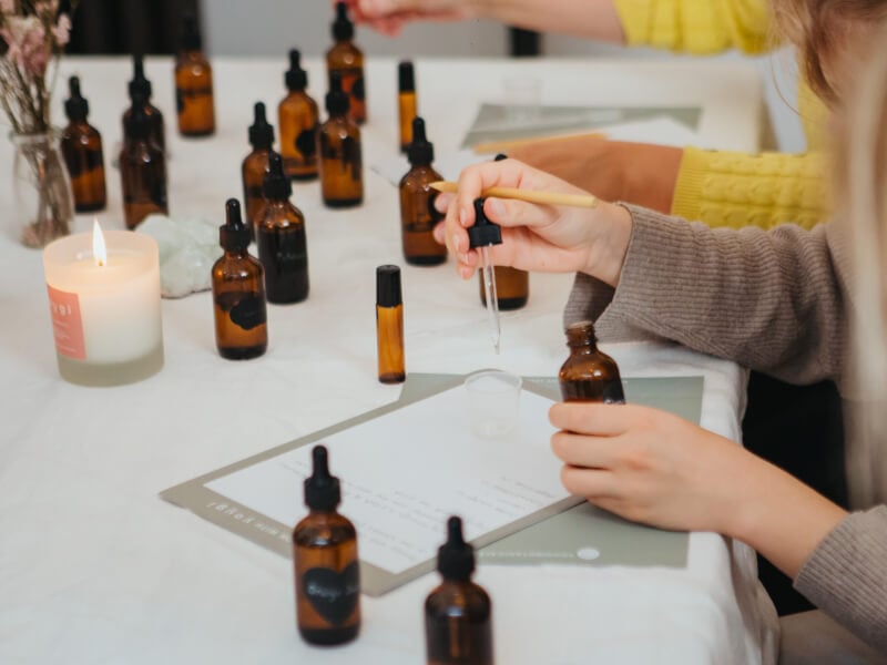 Hands using bottles and pipettes in a perfume making class